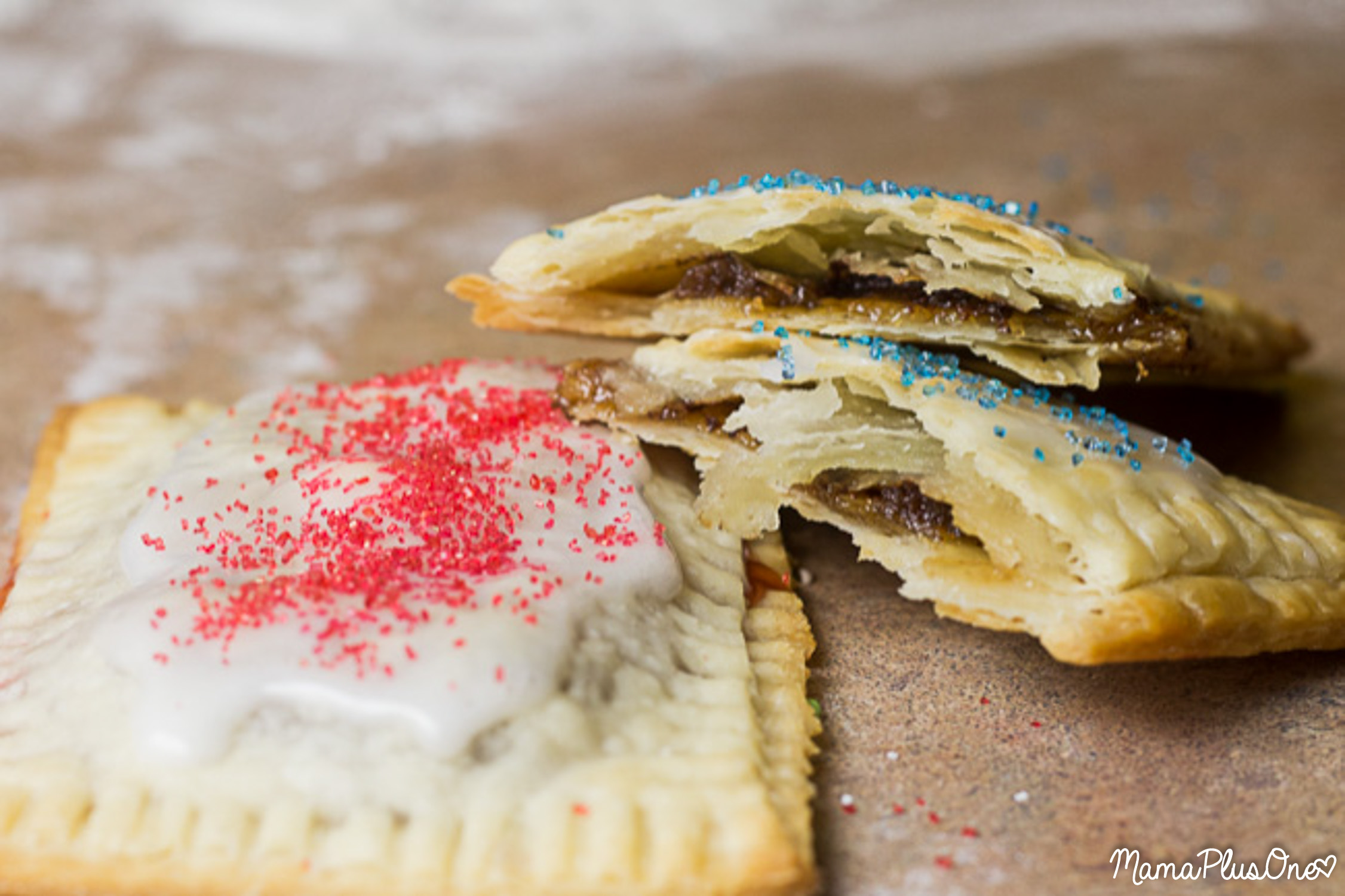I love a good toaster pastry, especially Pop Tarts, but if you make these, you are never going to buy storebought again… flaky crust, hearty filling, deliciously sweet, tender flavor, and sprinkles in any color of the rainbow! Plus, they’re super easy to make with a semi-homemade filling! Get these yummy toaster pastries on your table in a matter of minutes (and get your kids enjoying some real fruit inside!) A homemade toaster pastry is the perfect breakfast treat for your on-the-go family! | homemade pop tarts | easy breakfast idea | breakfast pastry recipe |